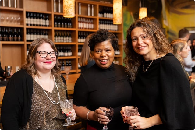 b97a415d-9965-4082-812f-453cfb6bf5de Three women with glass in hnad