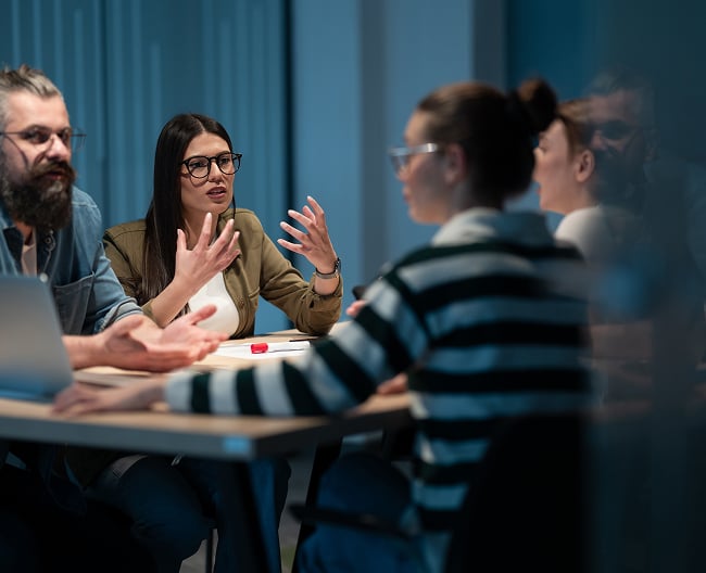 istockphoto-1574849844-1024x1024 group at table talking in the office